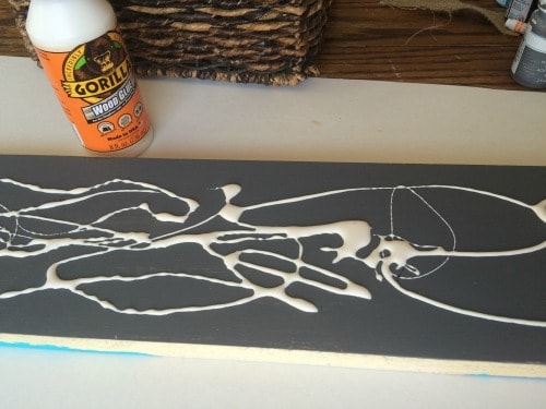 applying glue to the baseboard to make paint crackle
