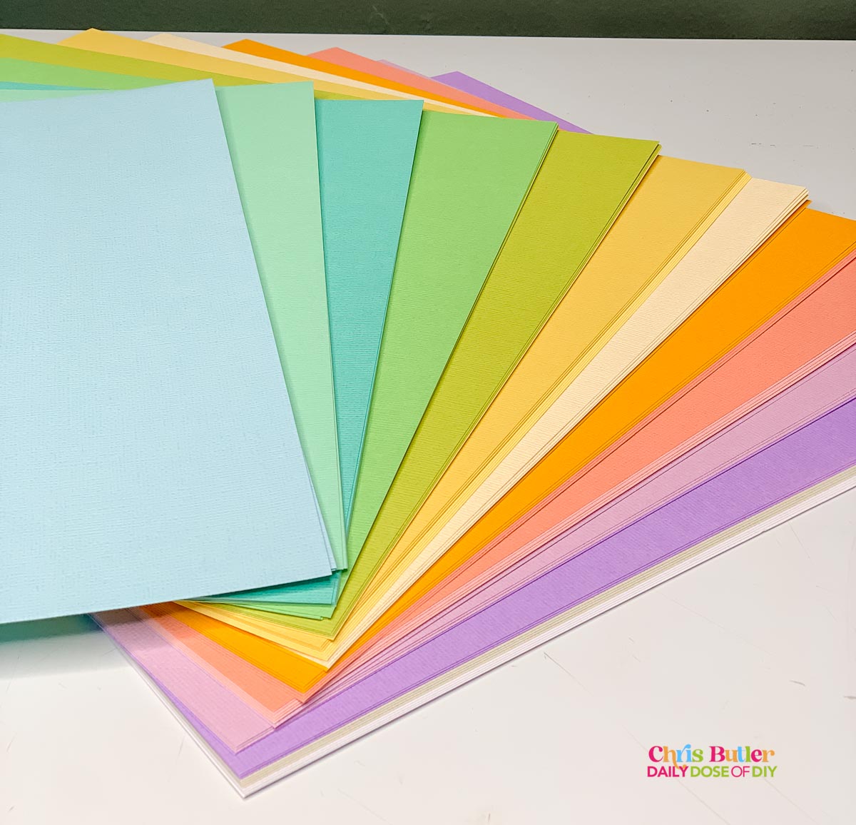 Cardstock used for paper crafts made with cutting machines with shades of blue, gree, yellow, orange, pink and purple. 