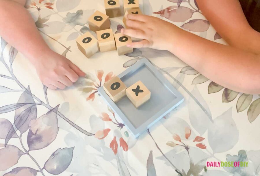 playing a hand made DIY Tic taco toe game with wood blocks