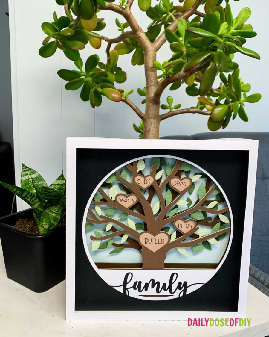 image of finished family tree craft with multiple shades of brown and greens with black border and white frame. 