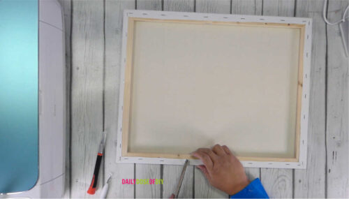 Removing the staples from the back of a canvas