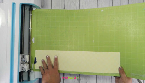 Loading Buffalo Plaid HTV into a Cricut Machine to cut for a Reverse Canvas