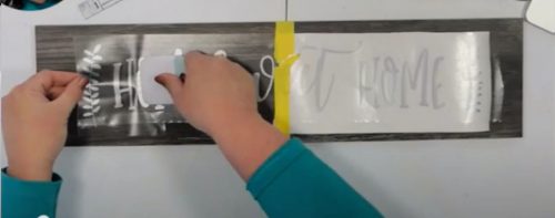 Burnish the vinyl to apply vinyl to wood or glass with the hinge method