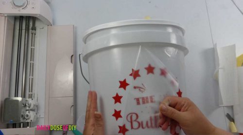 remove the transfer tape from the vinyl decal on the camp bucket