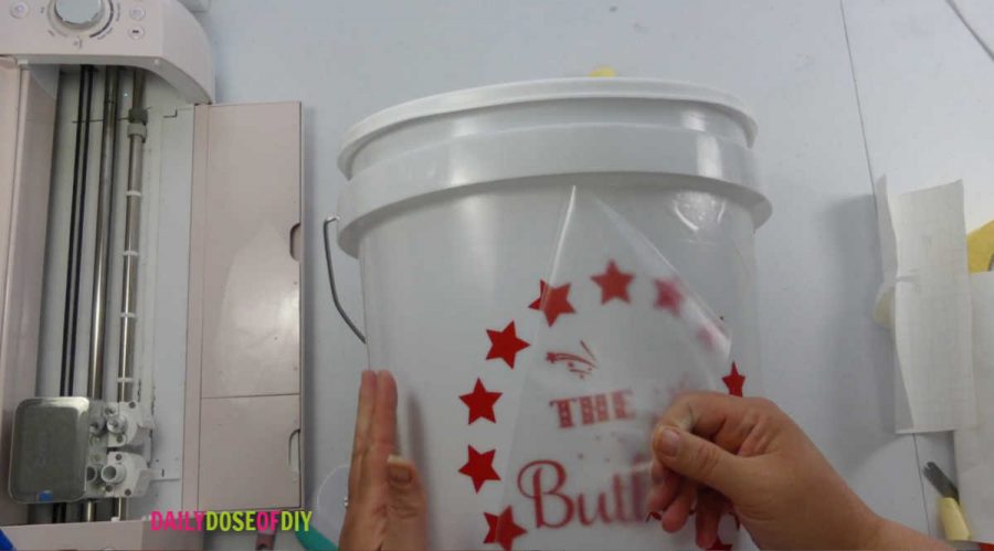 remove the transfer tape from the vinyl decal on the camp bucket