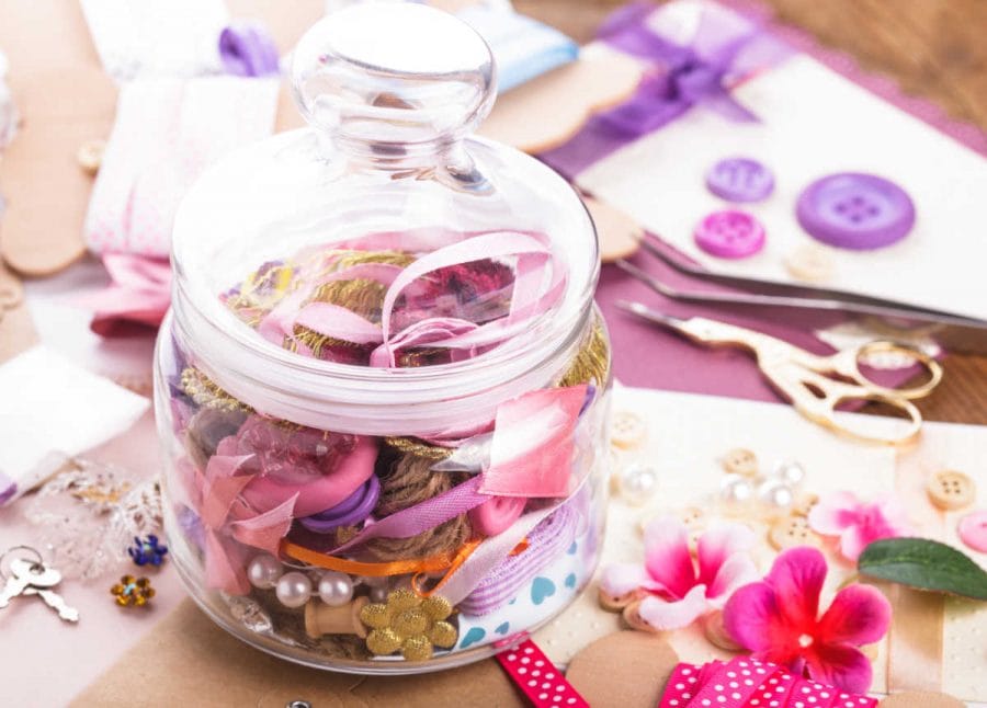 Scrapbooking craft materials organized in a glass jar