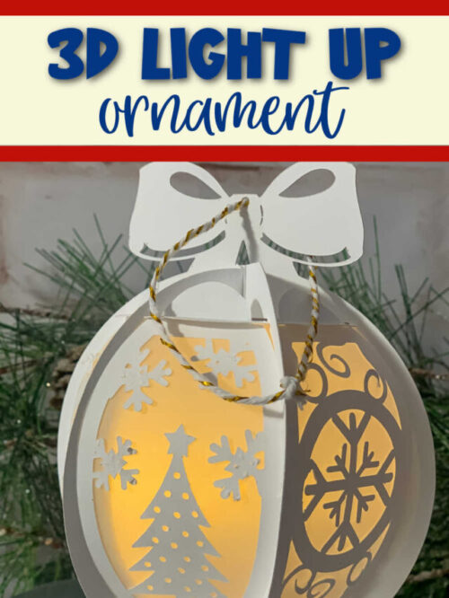 3d white paper ornament with a christmas scene with LED lights in the center