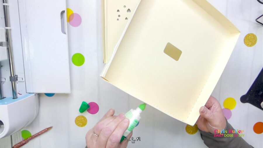 adding glue to the back of a cream colored shadow box frame 