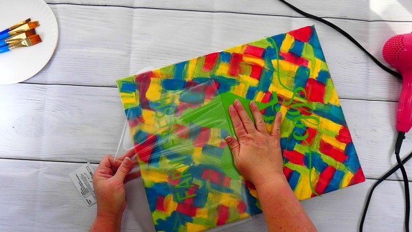 Remove the transfer paper from the design on the hot mess canvas