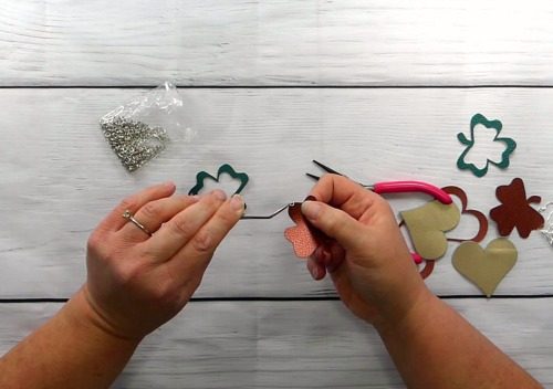 Put on the first piece of the leather shamrock onto the jump ring