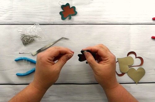 Add the fishhook to the leather earring to finish