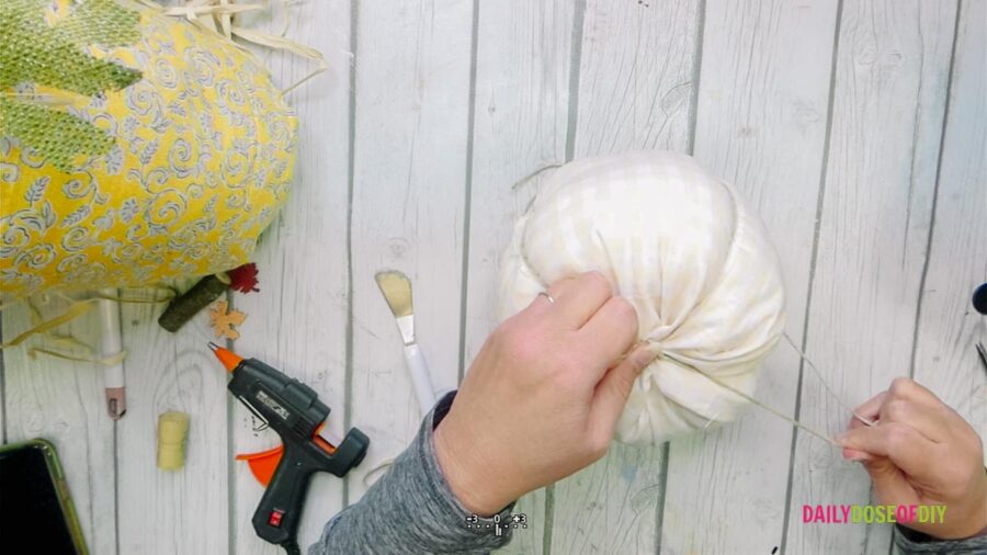Tying the end of the string to make a DIY fabric Pumpkin 