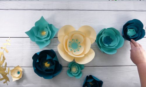 Arrange the paper flowers for your wall back drop on a table