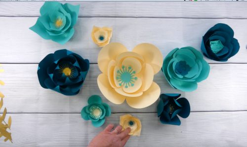 Arranging flowers for a paper flower wall back drop
