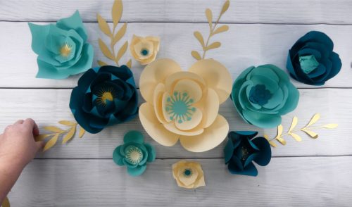 Add the greenery to finish the paper flower wall display