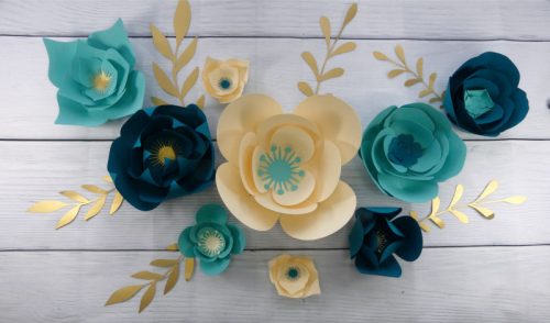 Teal and cream paper flowers used to make a DIY paper flower wall display at home