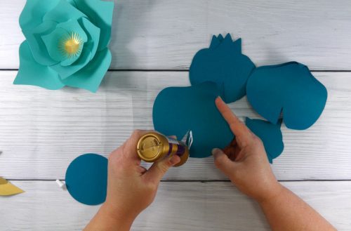 gluing together the paper flower to make a paper flower display