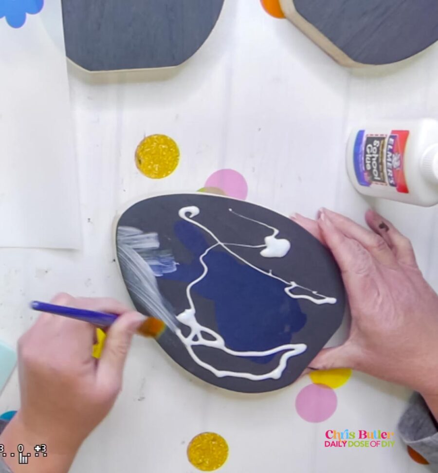 applying elmers scool glue on a wooden egg to make crackle paint 