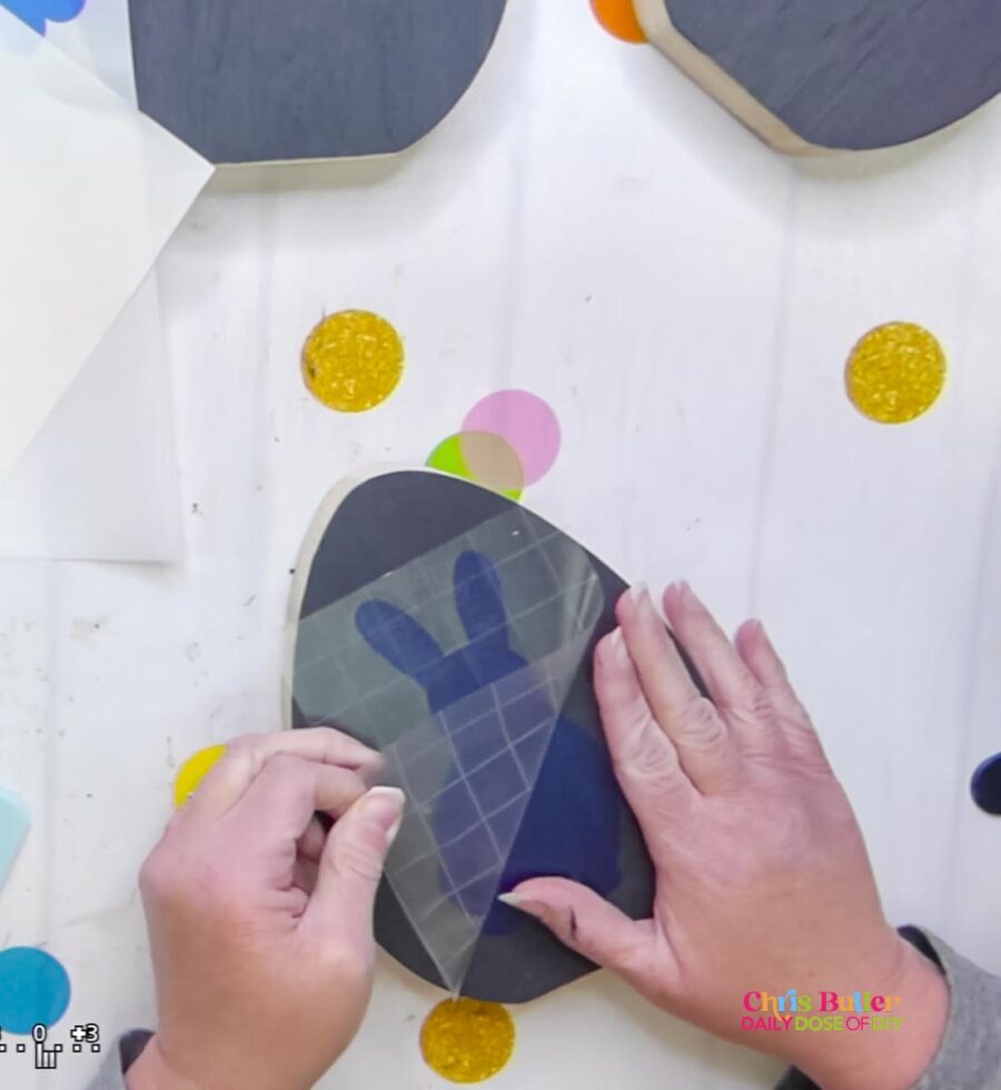 removing the transfer tape from a stencil on a wooden egg
