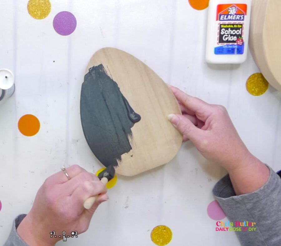 painting a wood egg with charcoal paint 