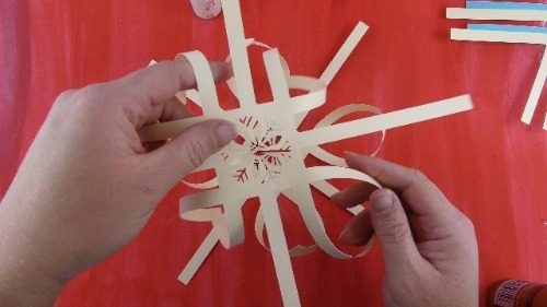 put the two snowflake sides together to form a 3D paper snowflake