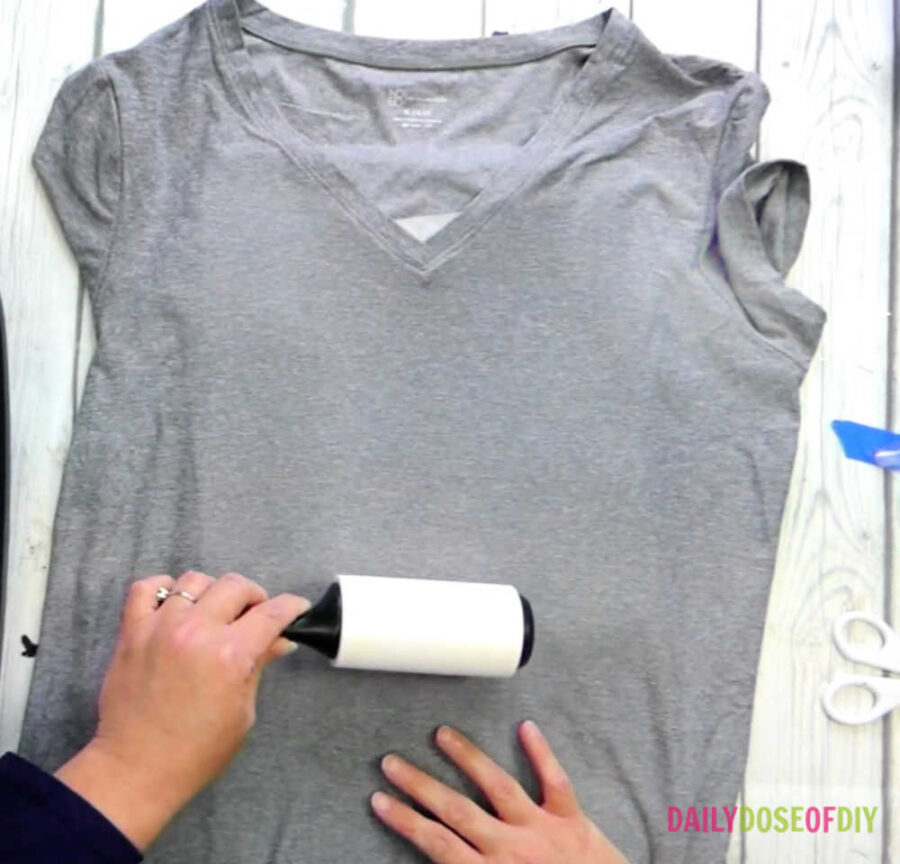 Using a lint roller on a t-shirt to prepare it for sublimation. 
