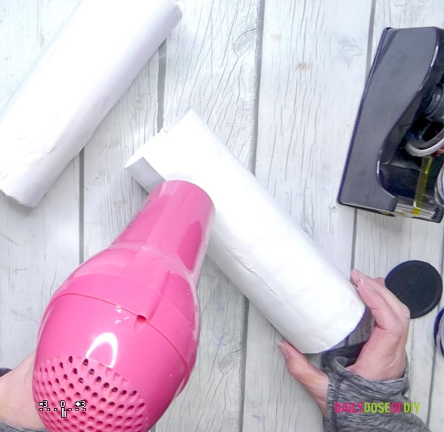 using a hot pink hair dryer to shrink the heat tube on the tumbler