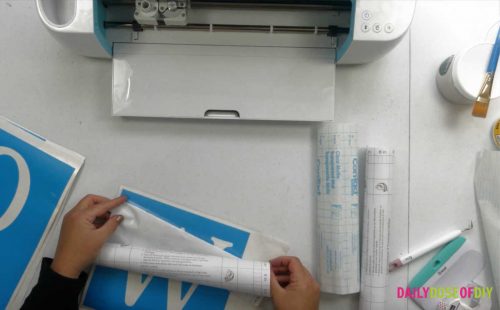 Applying transfer tape to the vertical welcome sign stencil