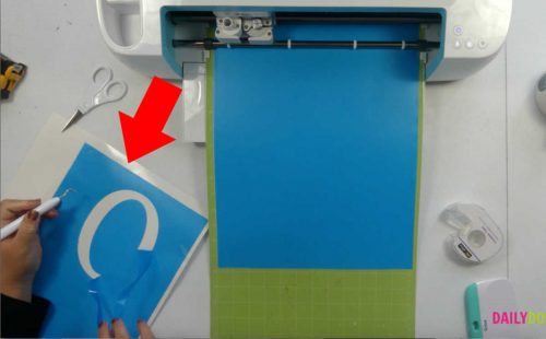 Weeding a vinyl stencil to paint a welcome sign