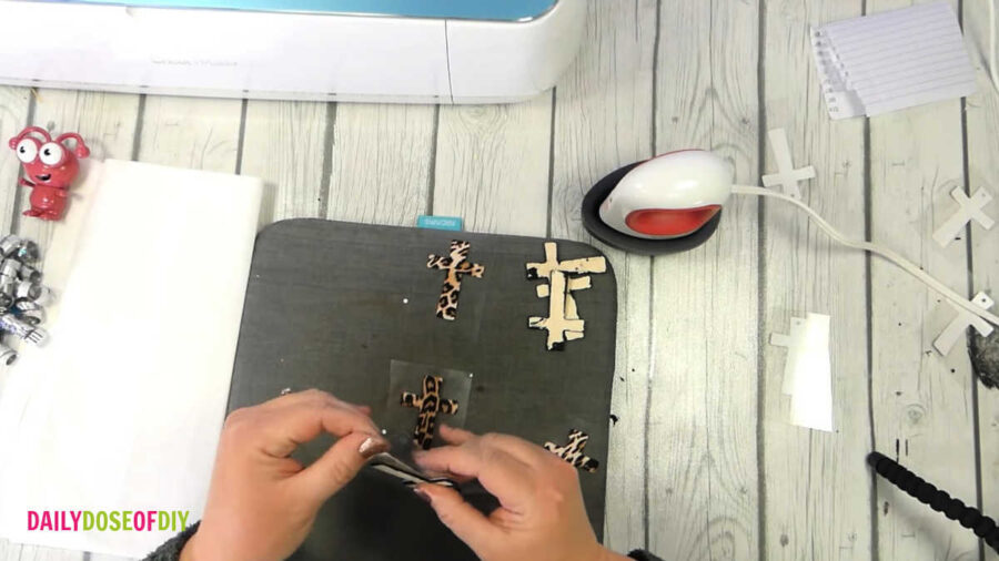 lining htv up on wooden cross before pressing